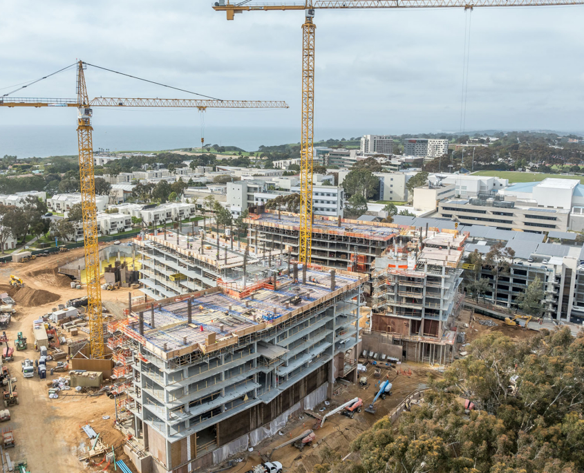 Aerial View Of New Dorm Complex Construction Site With Yellow Cranes