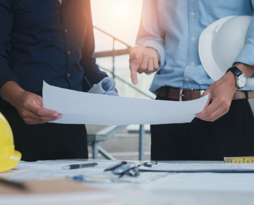 Engineering Objects On Workplace With Partners Interacting On Background